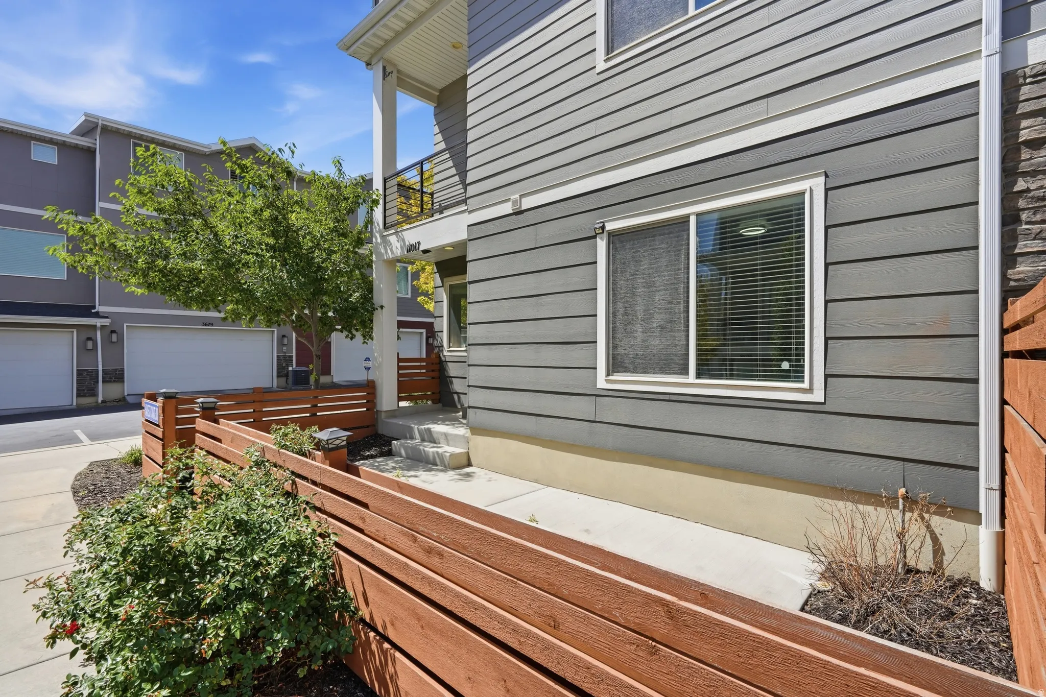 Exterior features gray horizontal siding and a white-framed window