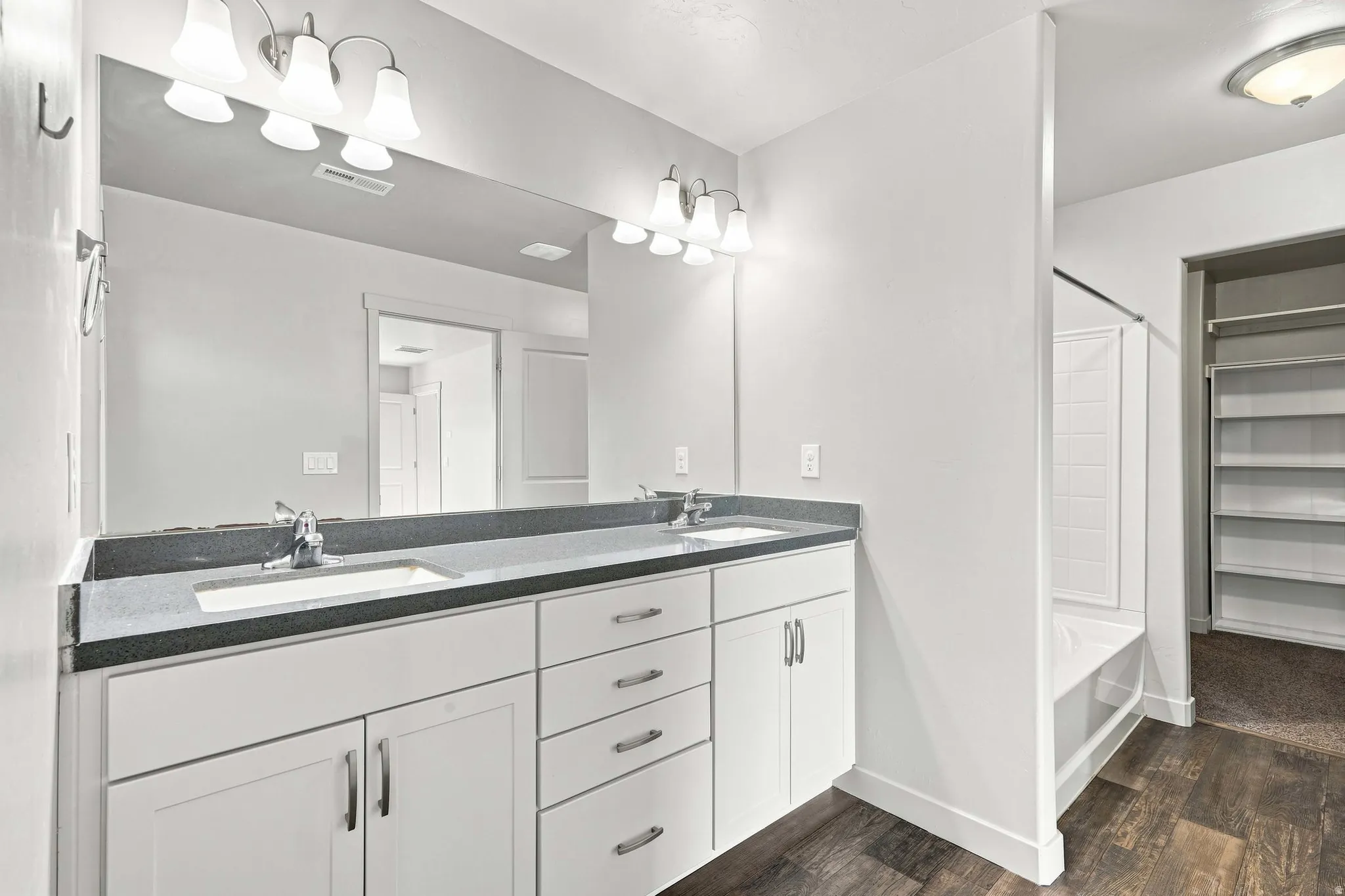Dual vanity with undermount sinks, dark countertop, and brushed nickel fixtures