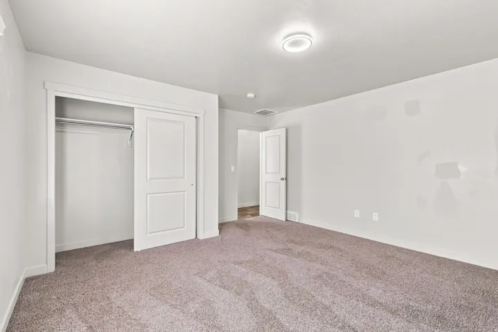 Plush carpet flooring, white walls, white trim, recessed lighting, and a bi-fold closet with two-panel doors