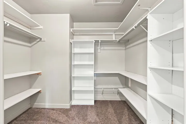 Custom closet system featuring extensive white shelving and hanging rods
