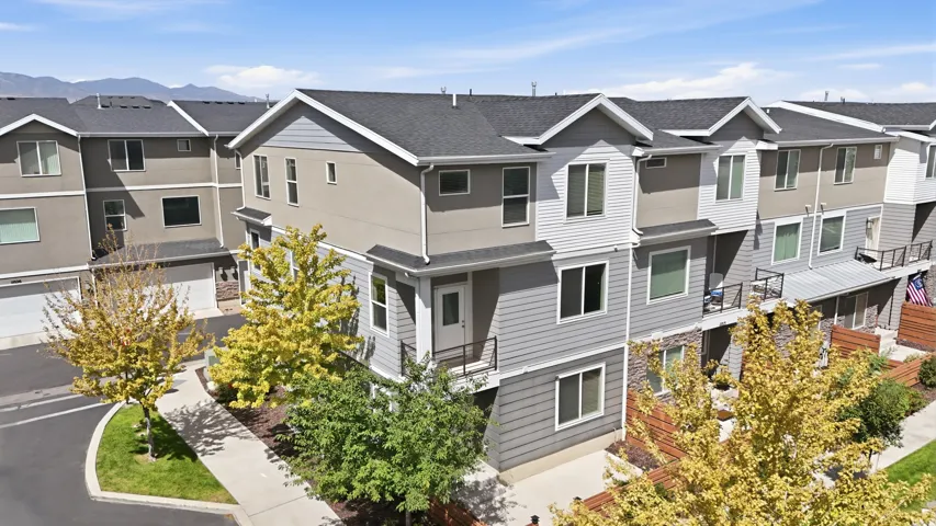 Townhome exterior featuring multi-level construction, stone accents, and varied siding