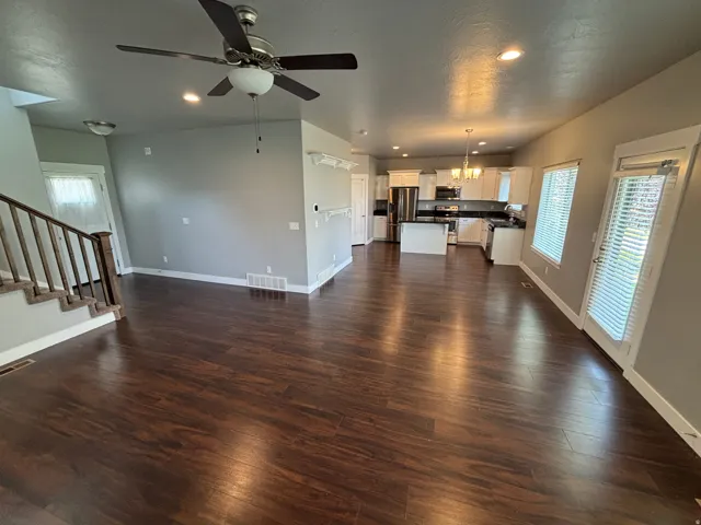 Open-concept living area featuring wood-finish flooring, recessed lighting, and a ceiling fan