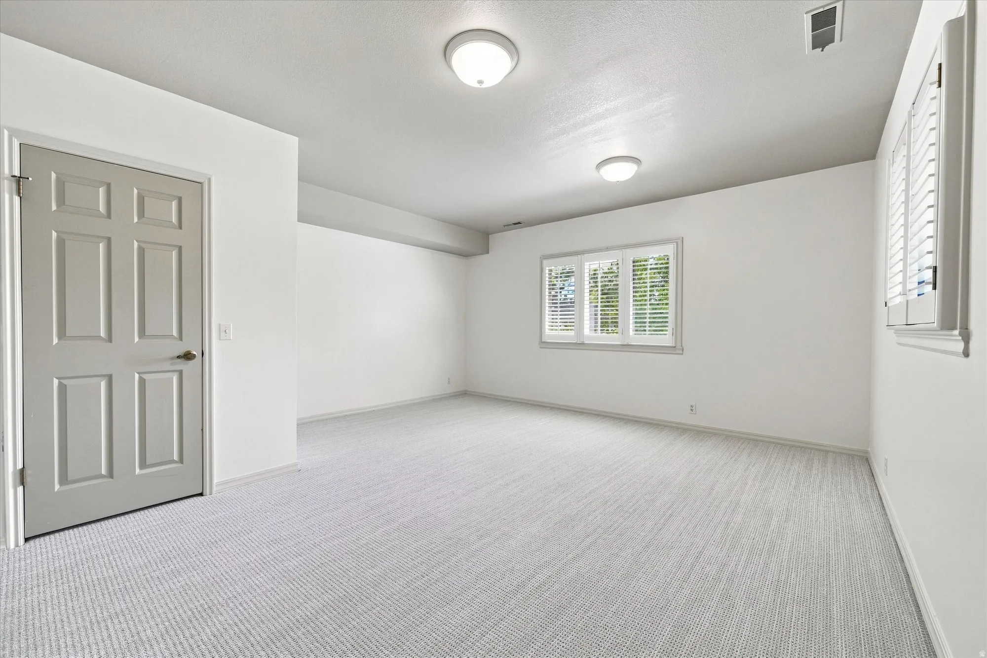 Lower level ensuite bedroom with new carpet and above-grade windows.
