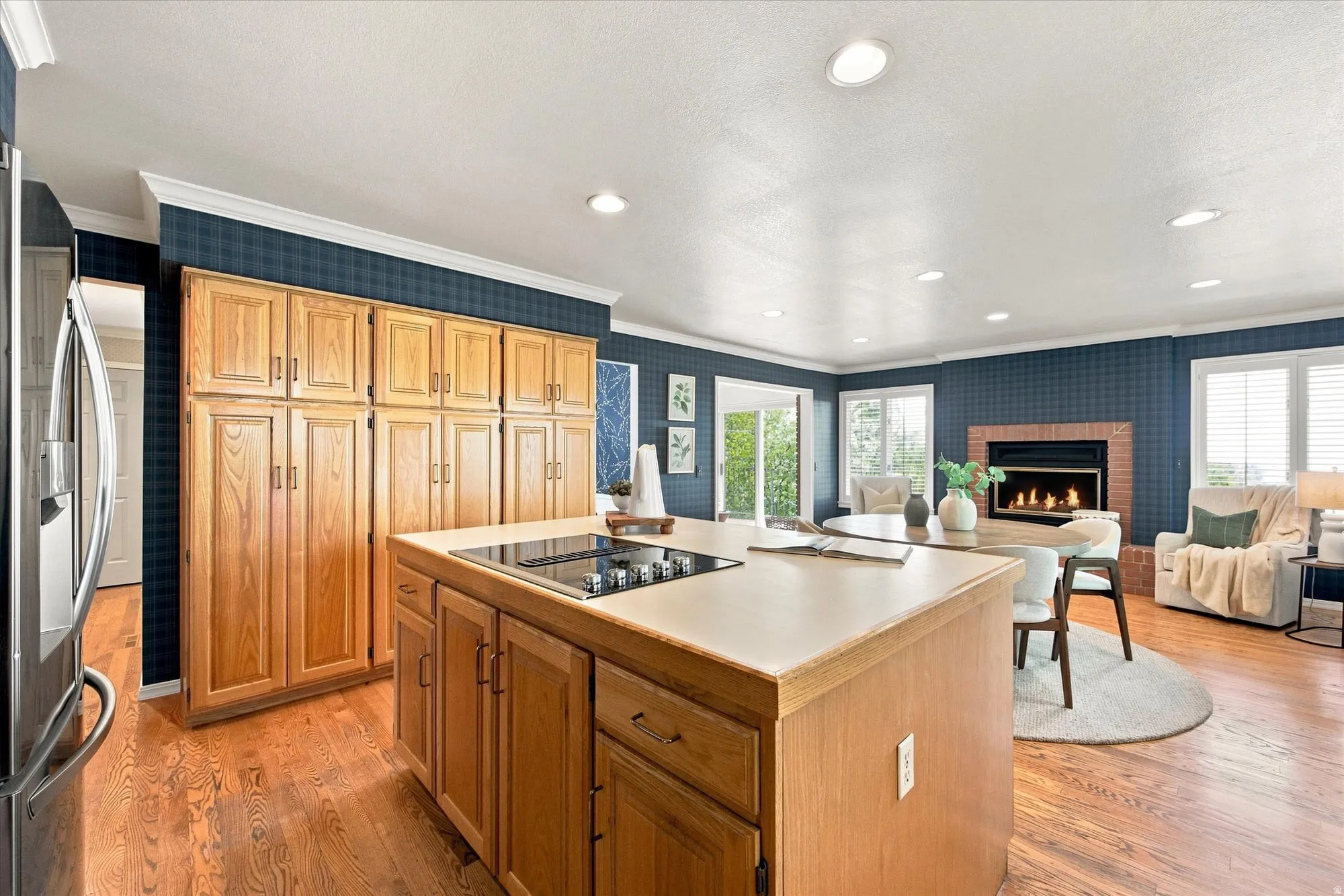 Light-filled, generously sized kitchen with an island, abundant storage, fireplace, and room to gather.