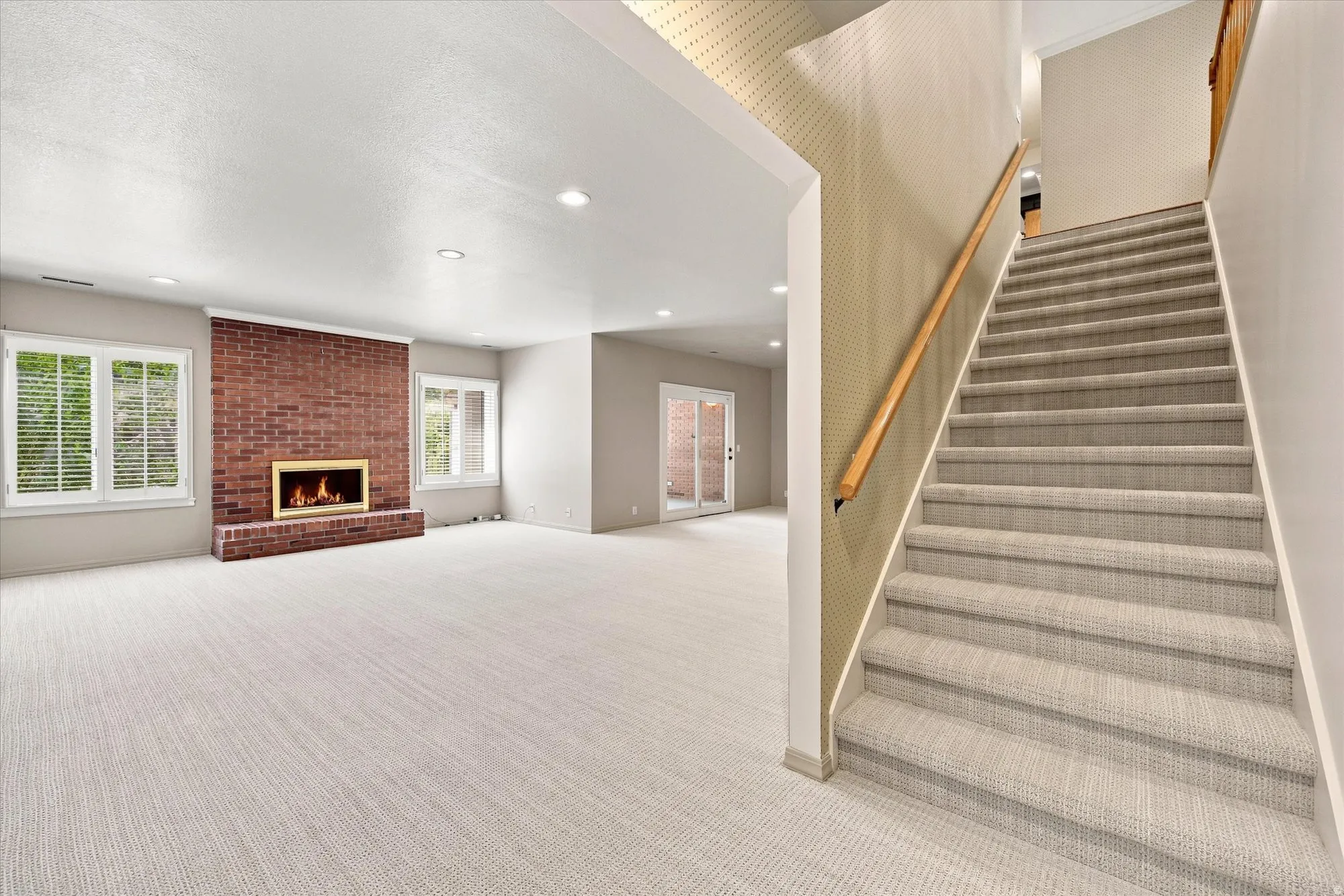 Expansive family room with new carpet, wet bar, gas fireplace and doors to a sunroom and the backyard. Windows are above ground.