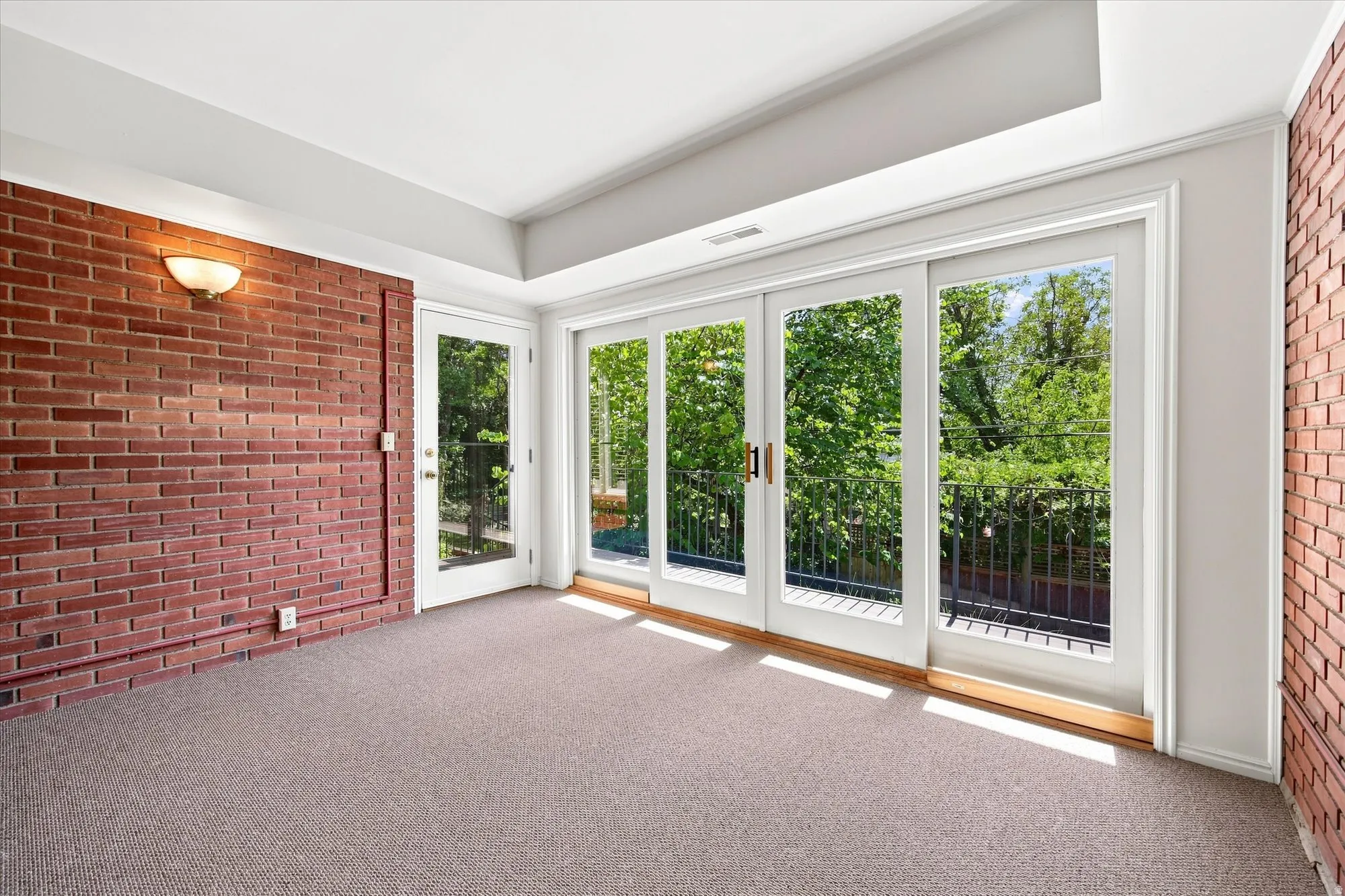 Lower level sunroom with access to balcony and backyard.