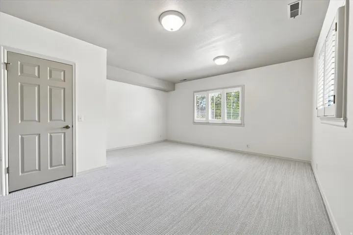 Lower level ensuite bedroom with new carpet and above-grade windows.
