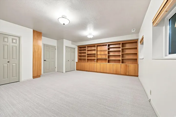 Spacious bedroom with new carpet, closets and built-in cabinetry.