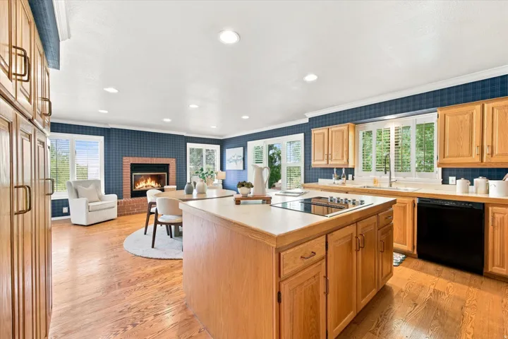 Light-filled, generously sized kitchen with an island, abundant storage, fireplace, and room to gather.