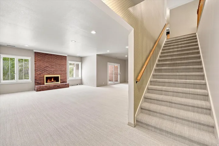 Expansive family room with new carpet, wet bar, gas fireplace and doors to a sunroom and the backyard. Windows are above ground.