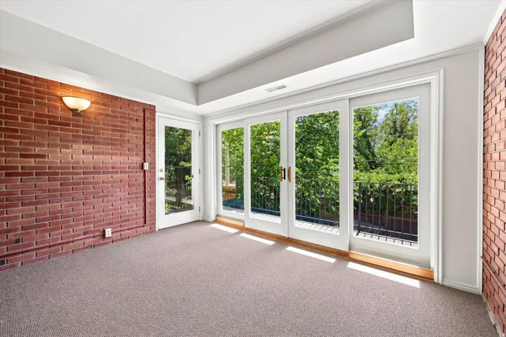 Lower level sunroom with access to balcony and backyard.