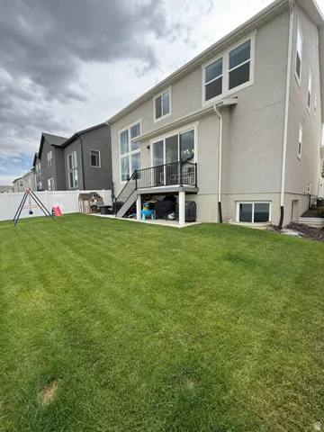 Expansive green lawn with a white privacy fence