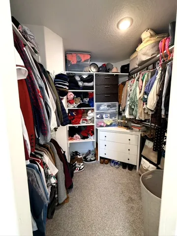 Built-in closet organization system featuring hanging rods, shelving, and drawer storage