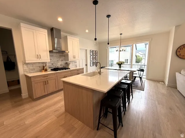 Gourmet kitchen with two-tone cabinetry, stone countertops, and a full tile backsplash