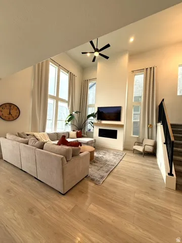 Vaulted ceilings with recessed lighting, wood-finish flooring, and a contemporary fireplace with a wood mantle