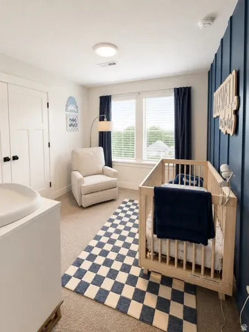 Carpeted room featuring a window with blinds, white panel doors, and a vertical shiplap accent wall