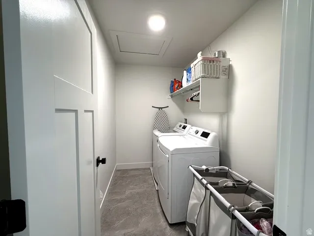 Laundry area featuring white walls, recessed lighting, wall-mounted shelving, and gray-toned flooring