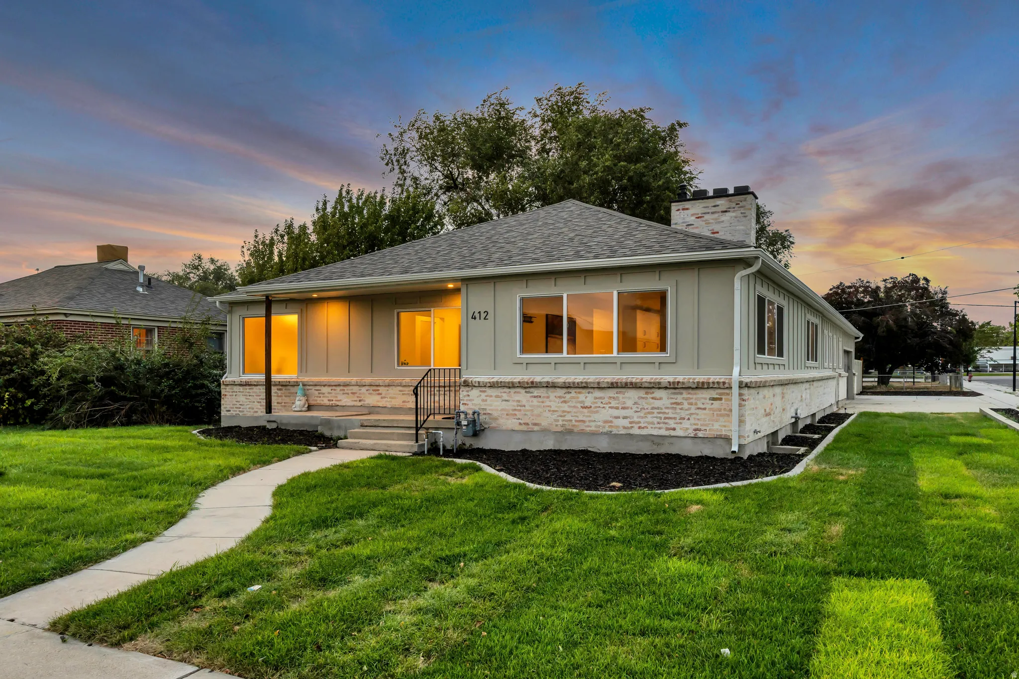Single-story residence featuring a gray shingle roof, light-toned siding, and a partial brick facade