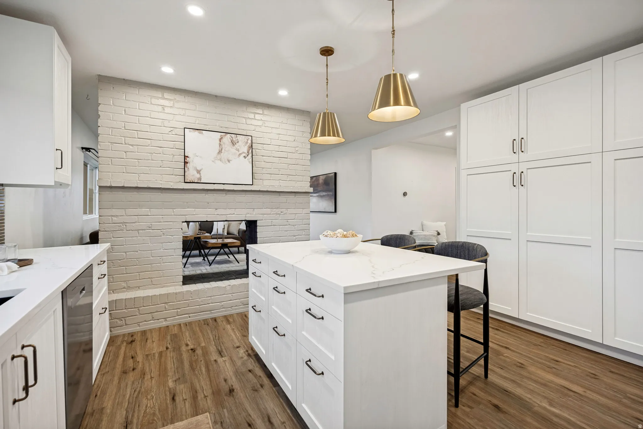 Kitchen featuring white shaker cabinetry, an island with quartz countertop, wood-finish flooring, and recessed lighting