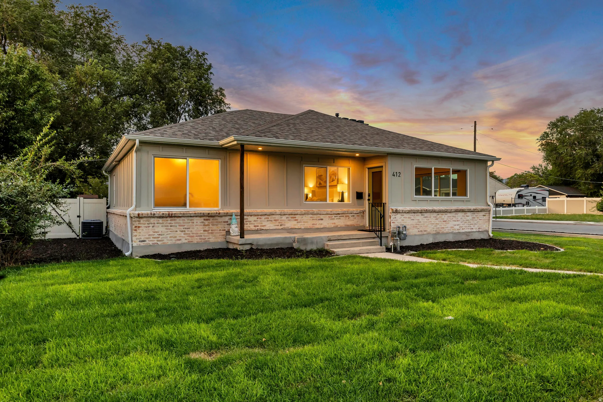 Mid-century modern residence featuring a light-colored brick facade, gray siding, and a dark shingled roof