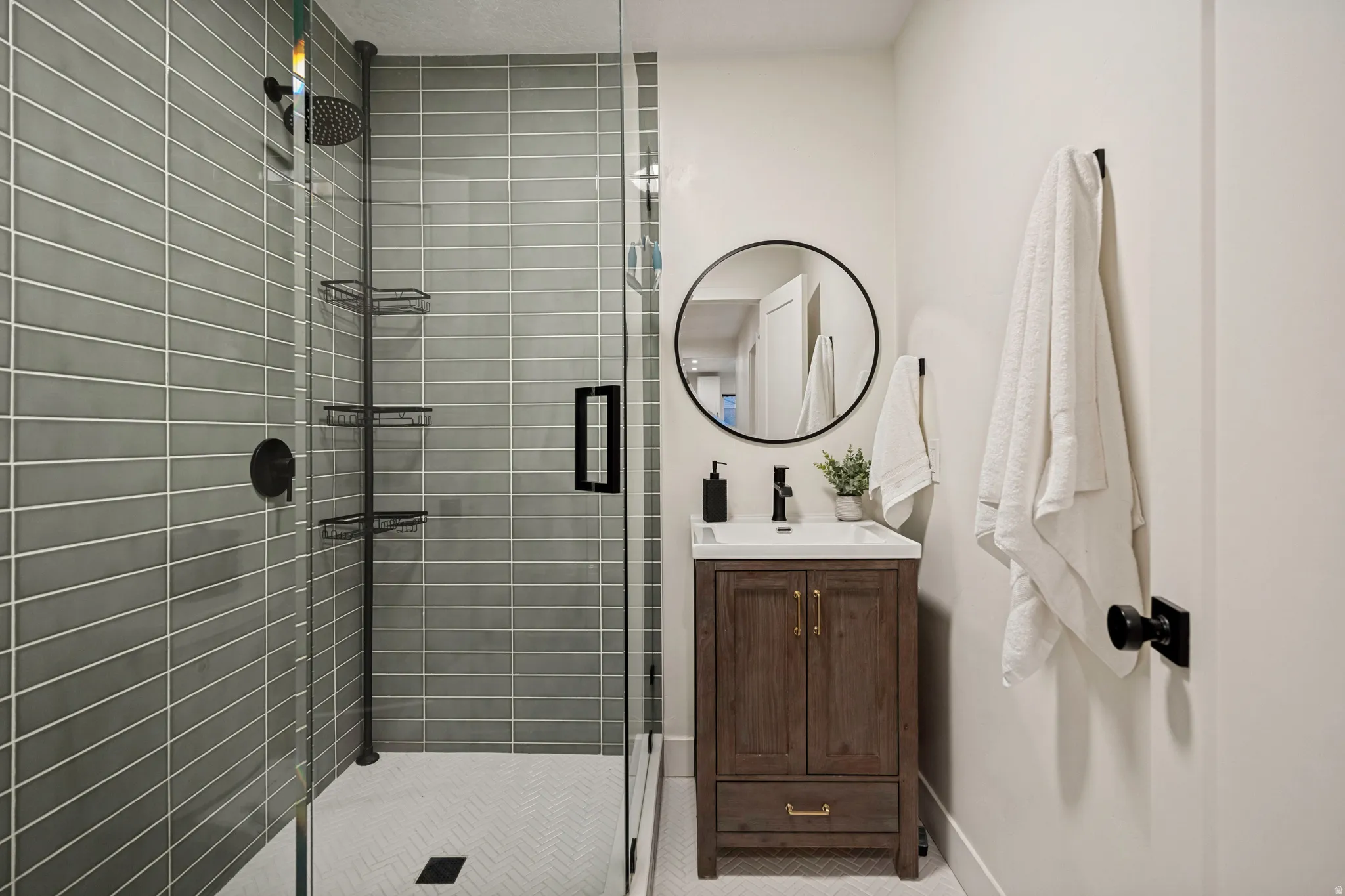 Glass-enclosed shower with horizontal tile surround and a tiled shower pan