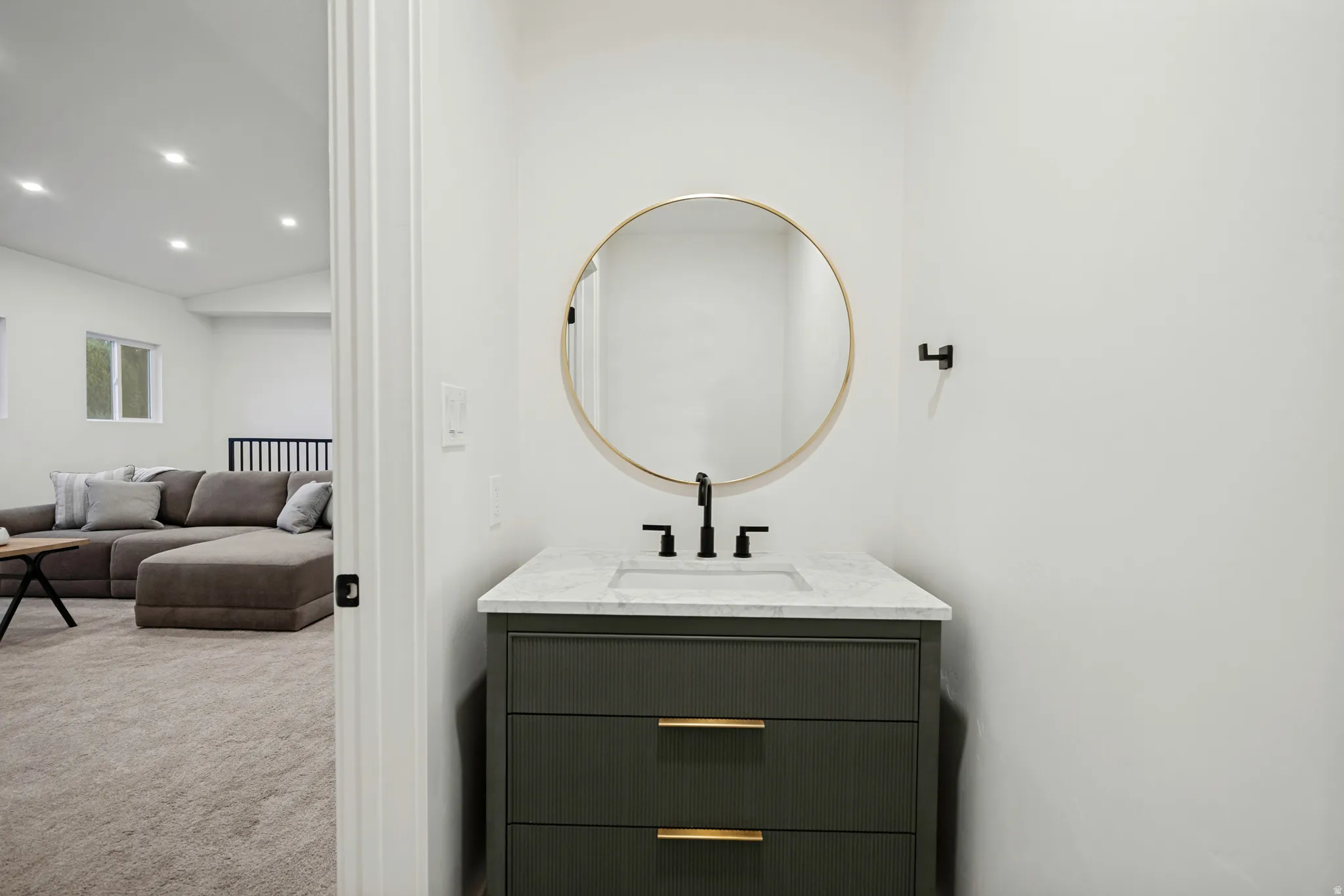 Modern vanity with a rectangular basin, black faucet, and brass hardware