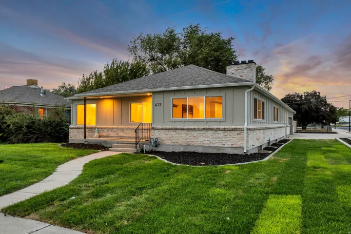 Light brick and siding exterior with a shingle roof and a concrete walkway
