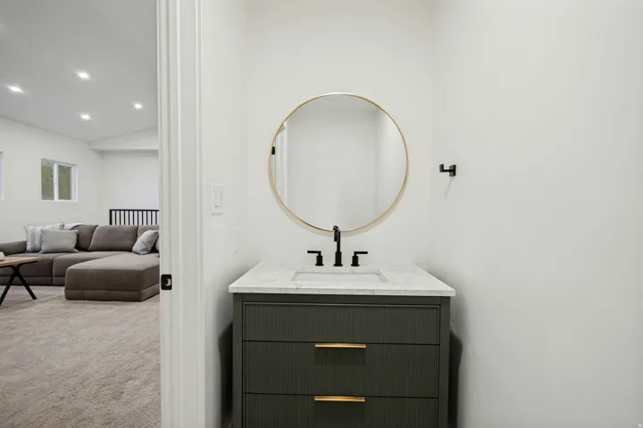 Modern vanity with a rectangular basin, black faucet, and brass hardware