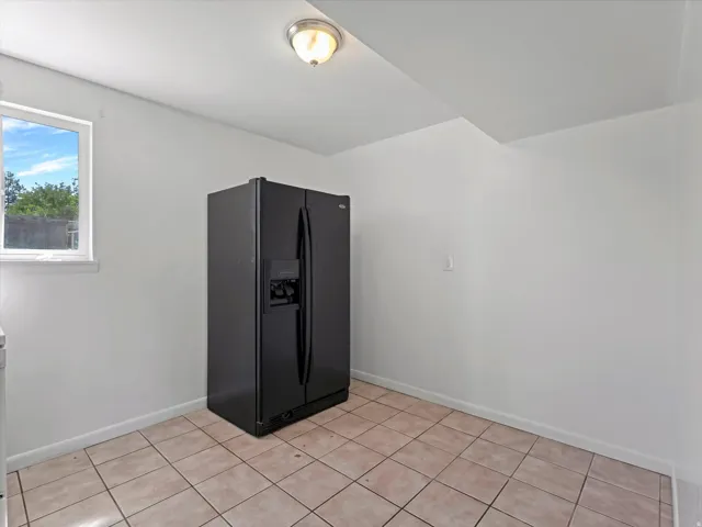 Tile flooring, white walls, and a window for natural light