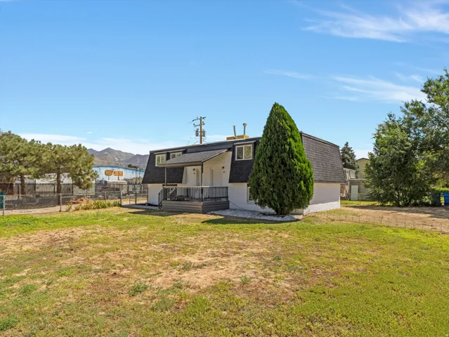 Two-story property with a dark shingled roof and white exterior