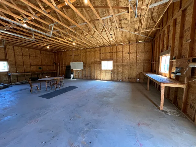Spacious open interior featuring exposed wood trusses and structural wood paneling