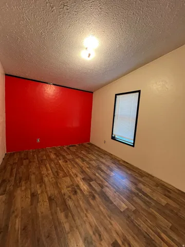 Wood-finish flooring, overhead lighting, window with blinds, and contrasting wall colors