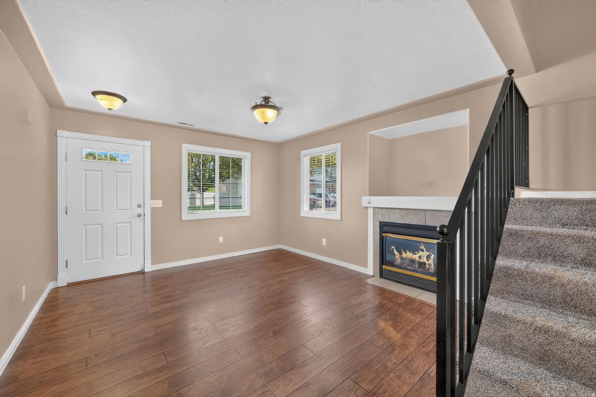 Wood-finish flooring, white trim, and a built-in fireplace with a stone surround