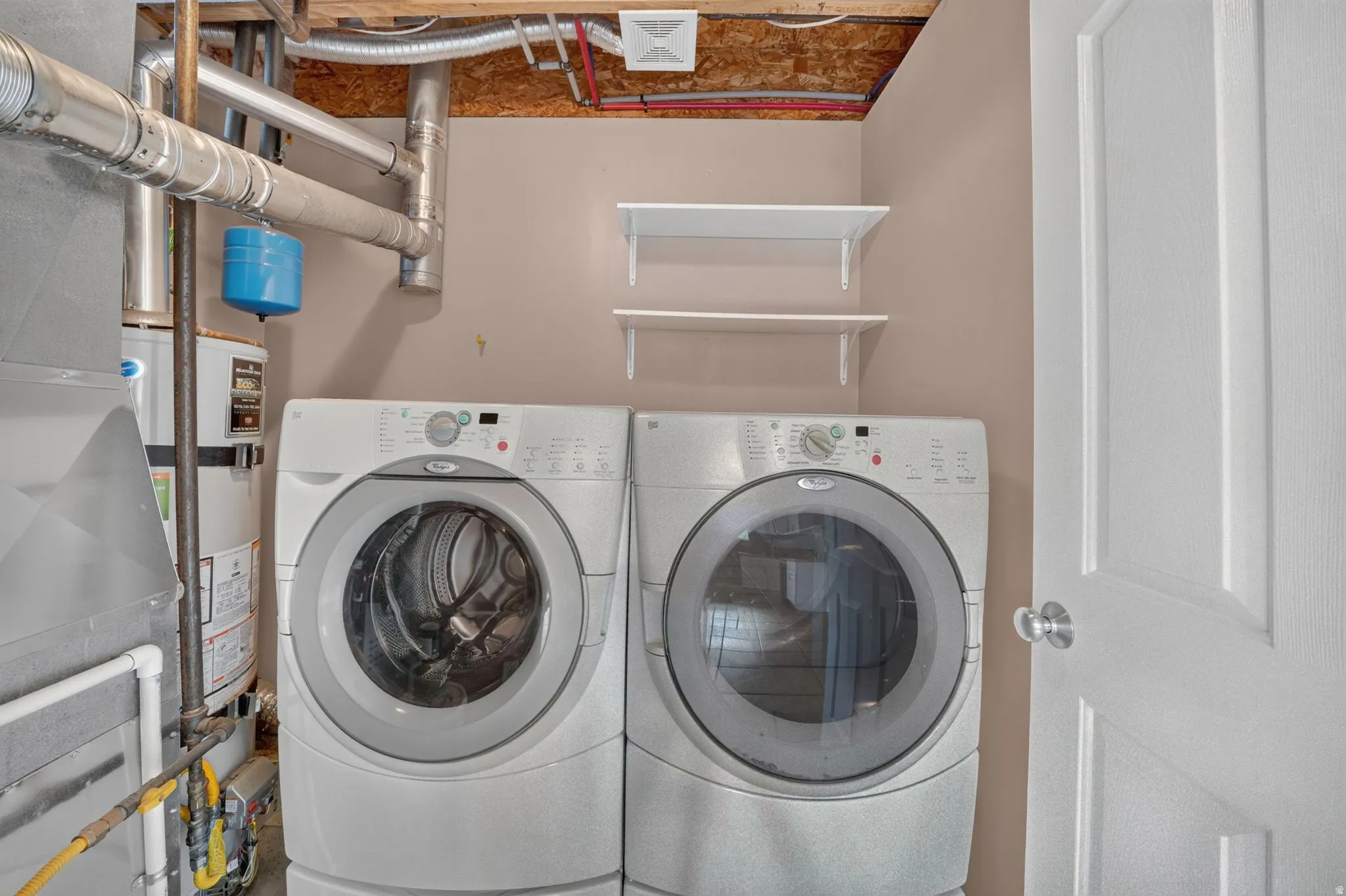Dedicated laundry area with two wall-mounted shelves