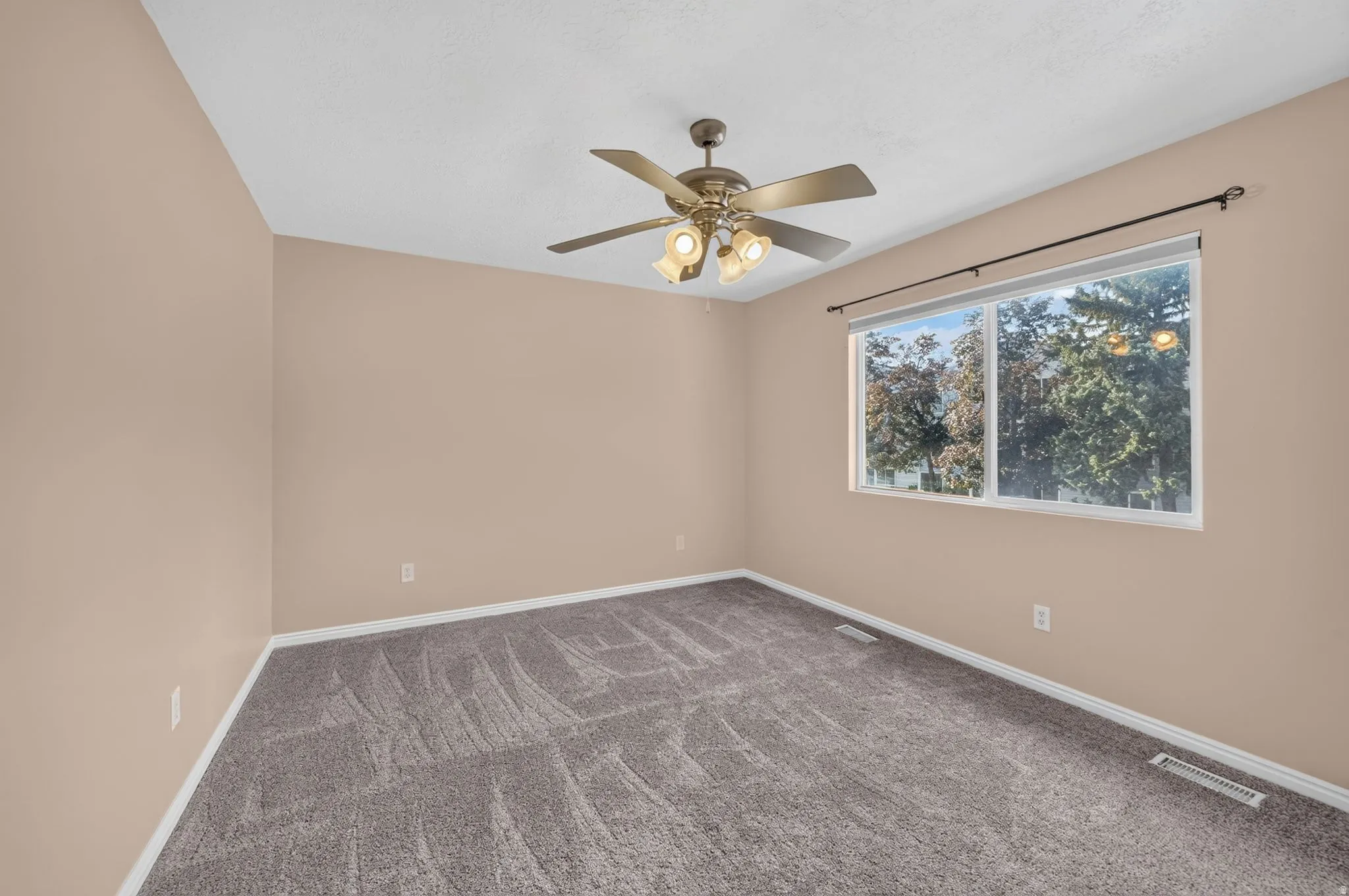 Recessed window with white trim, a decorative curtain rod, and a multi-speed ceiling fan with integrated lighting