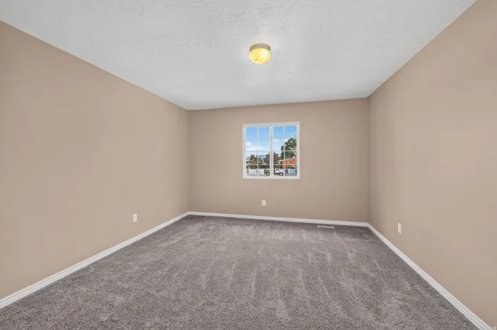 Neutral-toned walls complement the gray carpeting