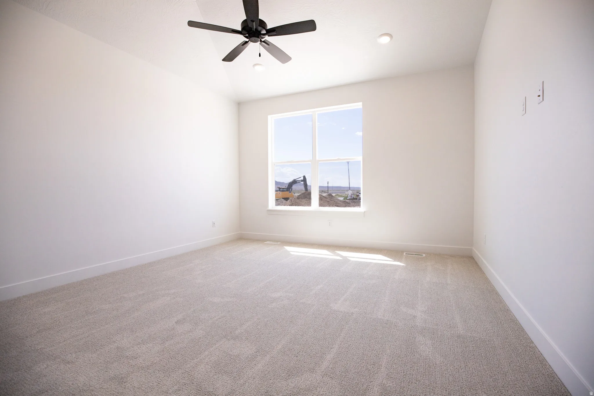 Primary bedroom on main level with vaulted ceiling and ceiling fan.