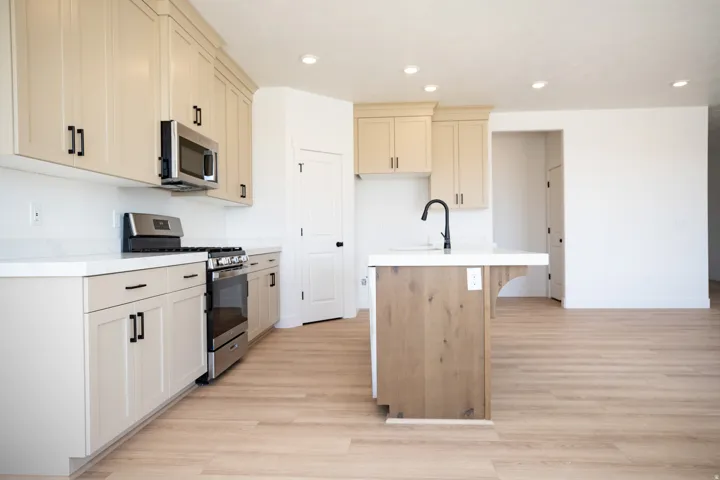 Terrific kitchen with ceiling height uppers, painted wood cabinets and stained wood island, quartz slab countertops, large corner pantry, gas range, microwave, built-in dishwasher and disposal.