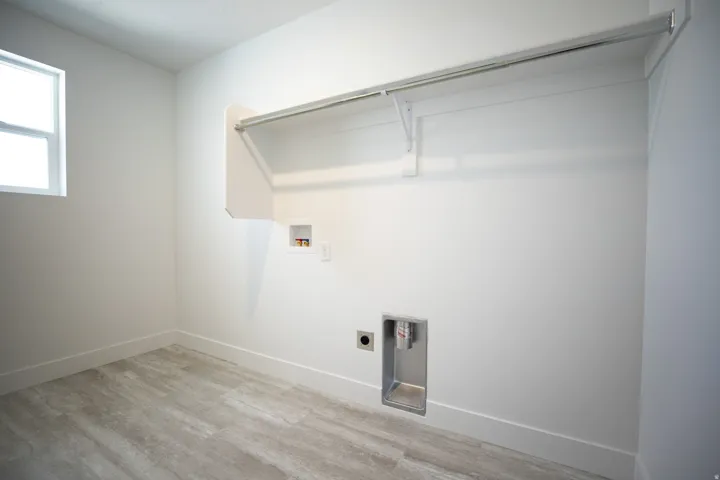 Full-size dedicated laundry room with natural light and washer/dryer hookups.
