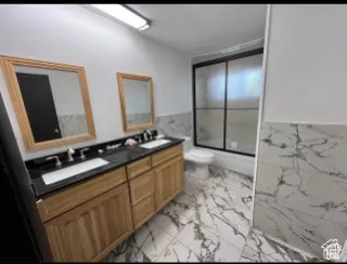 Dual vanity with wood-finish cabinetry and dark countertops