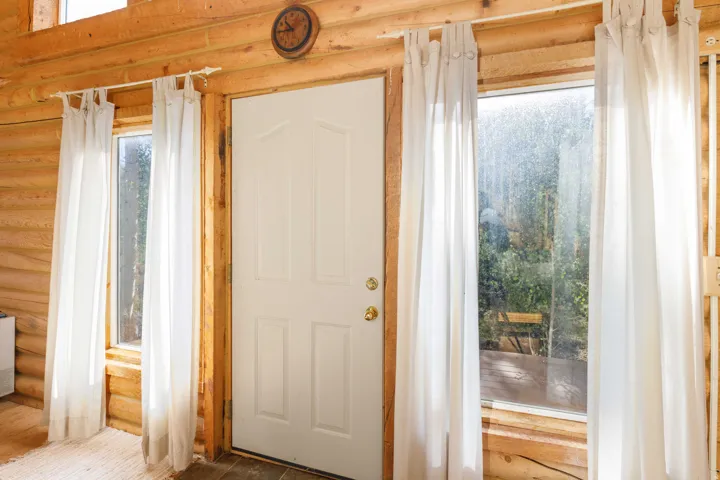 Wood-finish walls framing a white paneled door with brass hardware