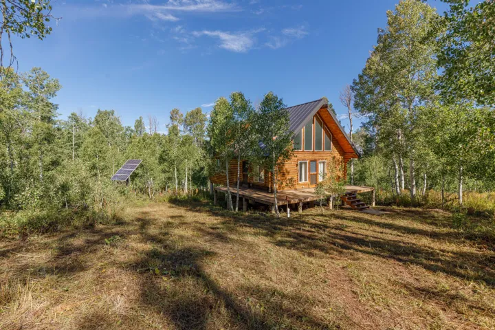 Charming A-frame residence nestled on wooded acreage with mature birch and pine trees throughout the property