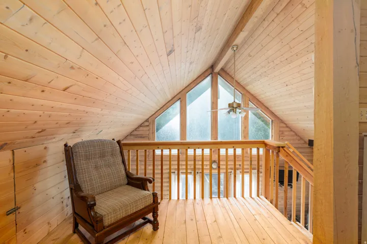 Vaulted wood-paneled ceilings, wood-finish flooring, wood railing, and triangular transom windows