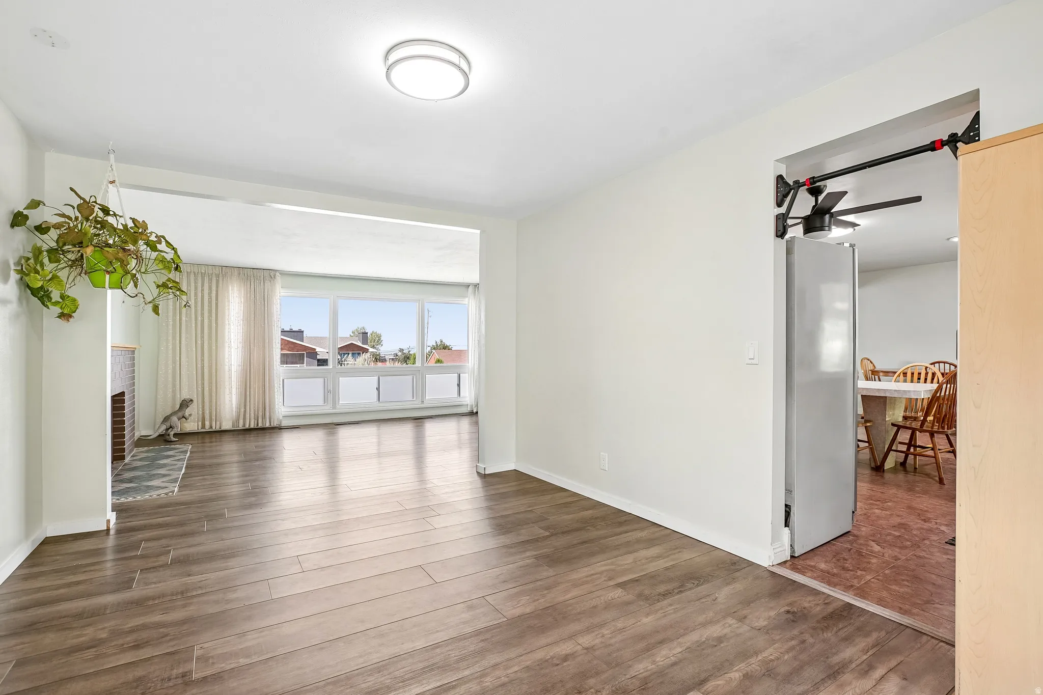 Wood-finish flooring throughout the main living space, with a fireplace featuring a tile surround