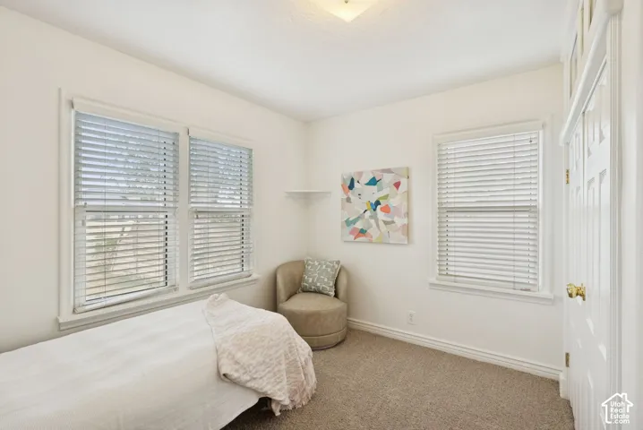 Neutral paint colors with carpet flooring, featuring two large windows, and a built-in wall shelf