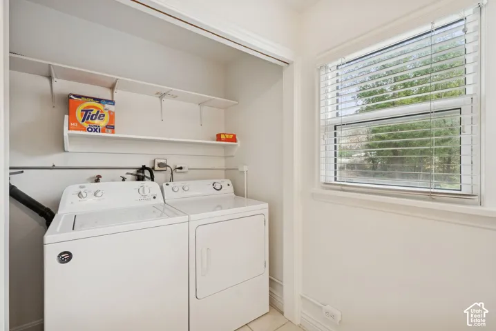 Built-in shelving, white appliance hook-ups, and a window with horizontal blinds