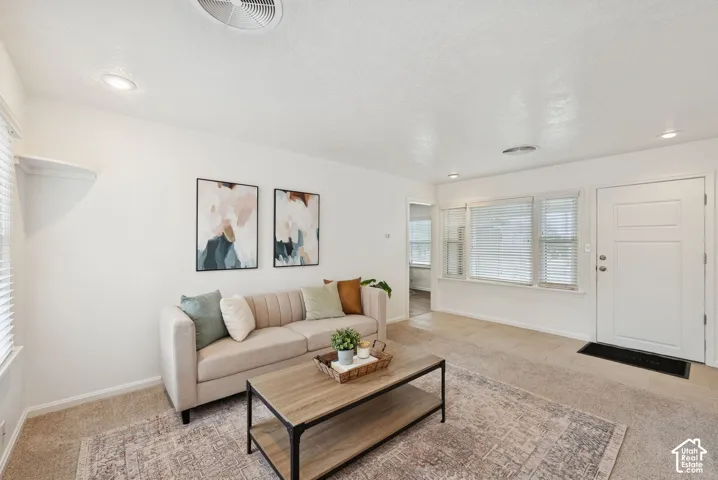 Neutral wall paint, recessed lighting, white trim, paneled entry door, and window treatments