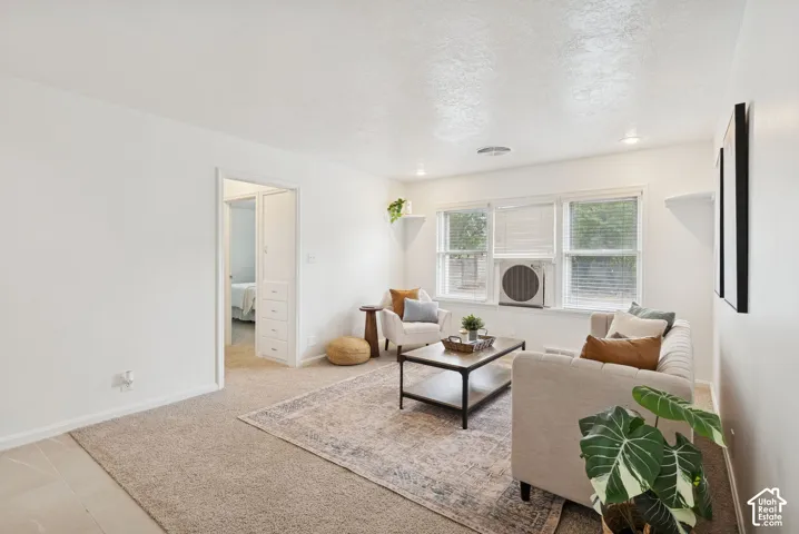 Recessed lighting, white walls, and a window with blinds provide illumination