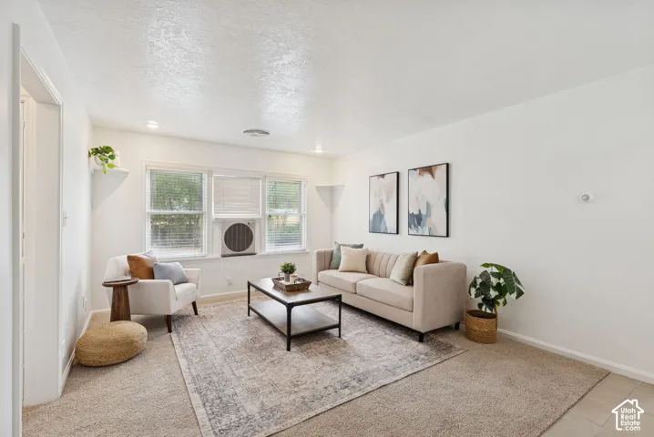 Recessed lighting illuminates the neutral-toned walls and carpet flooring