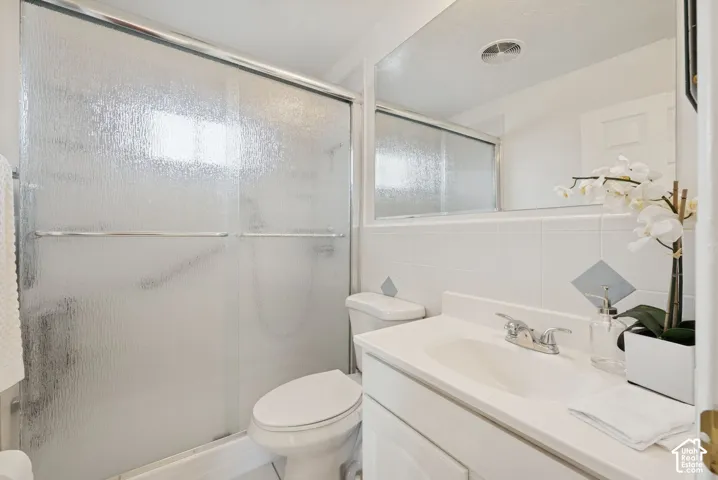 White vanity with an integrated sink, polished chrome faucet, and expansive wall mirror